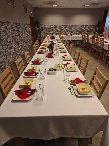 Sala restauracyjna z długim stołem nakrytym do posiłku dla grupy